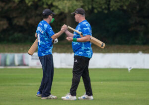 Joe Harrison and Phil Daniels shake hands in celebration.