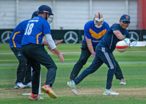 Gerald Porter plays ball to fine leg whilst surrounded by Sussex fielders.